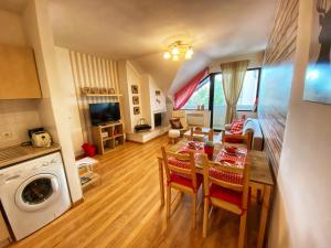 a kitchen and living room with a table and chairs at Papa Moose Pamporovo in Pamporovo