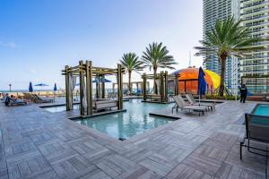 a swimming pool with a playground and palm trees at Amazing views on the 29th floor 2BR Beach Resort in Hallandale Beach