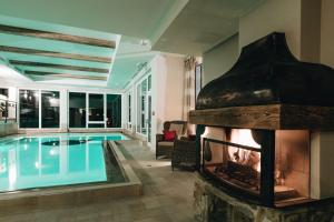 a pool with a fireplace next to a swimming pool at DER GREIL - Wein & Gourmethotel in Söll