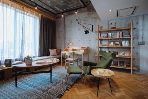 een woonkamer met een tafel en stoelen en een bureau bij KLoe Hotel in Kuala Lumpur