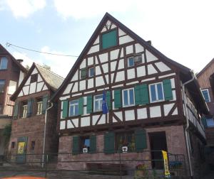 a half timbered house with green and white trim at Meisterhaus Alpirsbach Loft in Alpirsbach