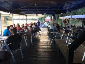 a group of people sitting at tables at a restaurant at Tisza-beach wild camping 5 in Szeged +71 photos