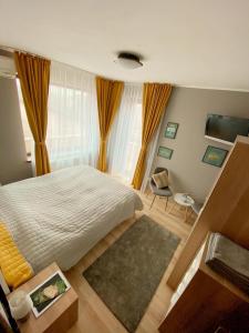 ein Schlafzimmer mit einem Bett, einem Tisch und einem Stuhl in der Unterkunft Sleep & Fly Apartment in Otopeni