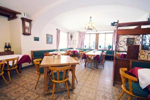 un restaurante con mesas y sillas y un reloj en la pared en Hotel-Gasthof Weitgasser, en Mauterndorf