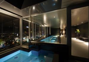 a building with a swimming pool and a view of the city at Cross Hotel Sapporo in Sapporo