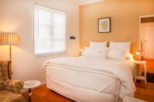 Un dormitorio con una gran cama blanca y una ventana en Annies B and B, en Warkworth