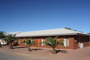 a building with palm trees in front of it at BIG4 Stuart Range Outback Resort in Coober Pedy