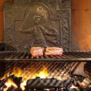dos piezas de carne cocinándose encima de una chimenea en B&B La Ruota Milano, en San Giuliano Milanese