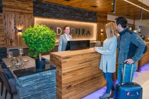 a group of people standing at a reception desk at Hotel Adapura Wagrain in Wagrain