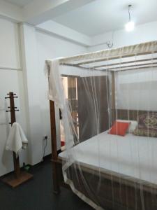 een slaapkamer met een hemelbed bij sinhagiri hotel & restaurant in Tangalle