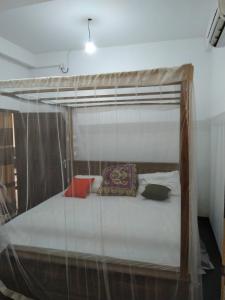 een bed met een hemelbed in een kamer bij sinhagiri hotel & restaurant in Tangalle
