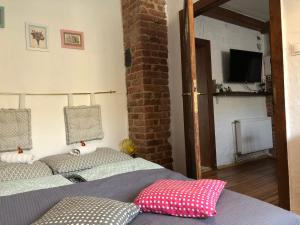 a bedroom with two beds and a television on a wall at Apartament Do Zobaczenia Olsztyn in Olsztyn