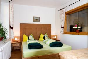 um quarto com uma cama com almofadas amarelas e verdes em Gasthaus Babsi em Soprabolzano
