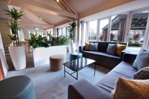 salon z kanapami, stołami i roślinami w obiekcie Waterloo Hub Hotel and Suites w Londynie