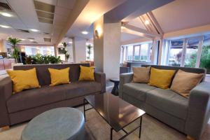 salon z 2 kanapami i żółtymi poduszkami w obiekcie Waterloo Hub Hotel and Suites w Londynie