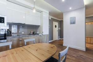 a kitchen and dining room with a wooden table at Apartament z balkonem Gdańsk Stare Miasto in Gdańsk