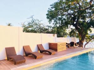un grupo de sillas y una mesa junto a una piscina en Altamare Dive and Leisure Resort Anilao, en Mabini