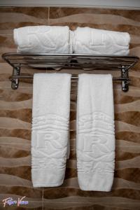 drei Handtücher auf einem Handtuchhalter im Bad in der Unterkunft Rehana Plaza Hotel in Kairo