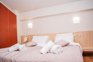 a bedroom with a large bed with towels on it at Platamon Centrale in Platamonas