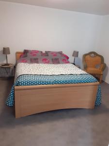 una camera con un grande letto con struttura in legno di " autour de la Baie " a Pleine-Fougères