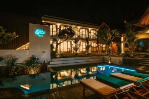 a hotel with a swimming pool at night at The Palms Canggu in Canggu
