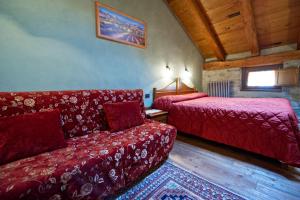 a living room with a couch and a bed at La Maison Des Vignerons Chambres D'Hotes B&B in Donnaz