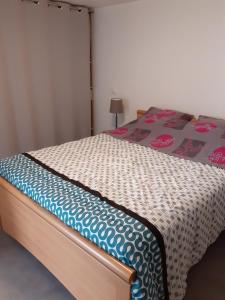 una camera da letto con un letto con un piumone di " autour de la Baie " a Pleine-Fougères