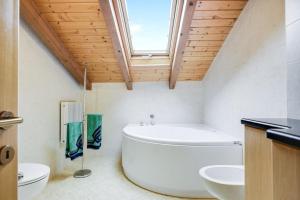 baño con bañera grande y lavamanos en La Rossa, en Moena