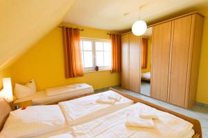 2 Betten in einem Zimmer mit gelben Wänden in der Unterkunft Ferienhaus Iris in Zempin
