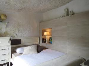 a small bedroom with a bed and a dresser at La cueva de Ángel B&B in Firgas