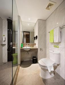 uma casa de banho com um WC, um lavatório e um chuveiro em MaxOne Platinum Hayam Wuruk em Jacarta