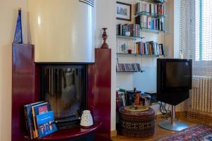 a living room with a fireplace and a tv at Ai Cinque Archi in Verona