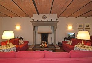 sala de estar con sofás rojos y chimenea en Badia di Morrona Agriturismo en Terricciola