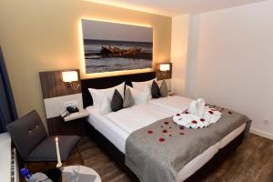 a hotel room with a large bed with roses on it at Hotel Sylter Hof in Westerland (Sylt)