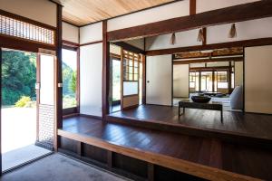 sala de estar con suelo de madera y ventanas grandes en せとうち古民家ステイズHiroshima 不老仙 en Shōbara