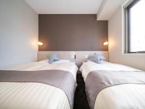 Postel nebo postele na pokoji v ubytování Super Hotel Premier Saitama Higashiguchi