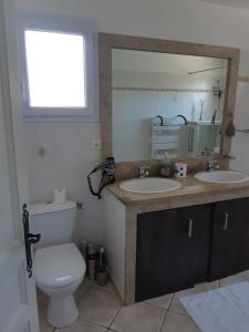 La salle de bains est pourvue de toilettes, de 2 lavabos et d'un miroir. dans l'établissement Veronique, à Appietto