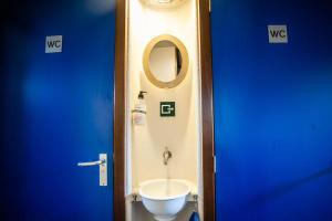 La salle de bains est pourvue de toilettes blanches et d'un miroir. dans l'établissement Amsterdam Hotelboat, à Amsterdam