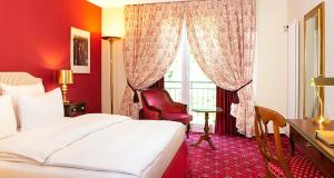 ein Schlafzimmer mit einem Bett, einem Schreibtisch und einem Fenster in der Unterkunft Victor's Residenz-Hotel Saarbrücken in Saarbrücken + 34 Fotos