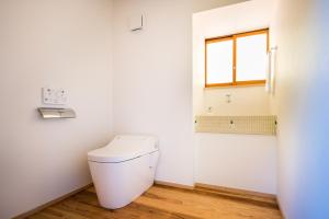 een wit toilet in een badkamer met een raam bij せとうち古民家ステイズHiroshima 不老仙 in Shōbara