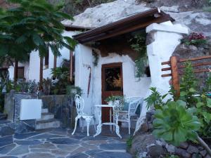 a small house with a table and chairs outside at La cueva de Ángel B&B in Firgas