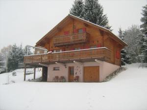 Cette cabane en rondins dispose d'un balcon dans la neige. dans l'établissement Chalet Gérardmer situé a LE THOLY, à Le Tholy
