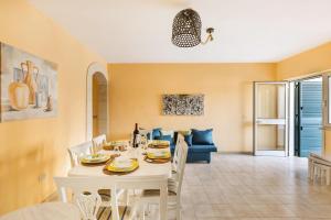 una sala da pranzo con tavolo e sedie bianchi di Casa Mya by BarbarHouse a Lido Marini