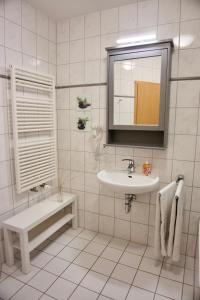 a white bathroom with a sink and a mirror at Am Strand in Juliusruh