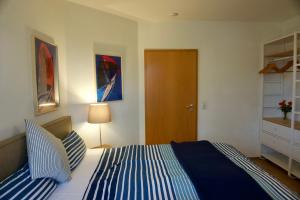 a bedroom with a bed with blue and white stripes at Am Strand in Juliusruh