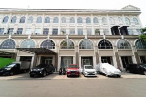 a large building with cars parked in front of it at KoolKost Syariah at Green Lake City in Gondrong
