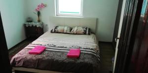 a bedroom with a bed with two pink pillows at Guest House The House in Plovdiv