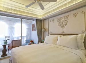 a bedroom with a large white bed with a ceiling at The Inside House in Chiang Mai