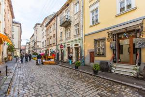 a cobblestone street in a city with buildings at Квартира подобово біля Площі Ринок вулиця Староєврейська 17 in Lviv