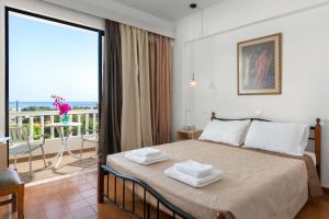 a bedroom with a bed with towels on it at Panorama Hotel in Gennadi